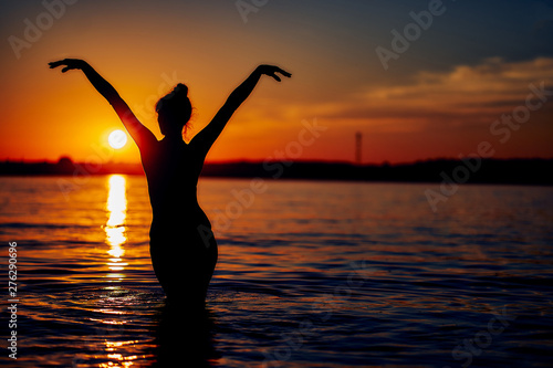 girl in the water in the setting sun. Beach holiday concept. silhouette image.
