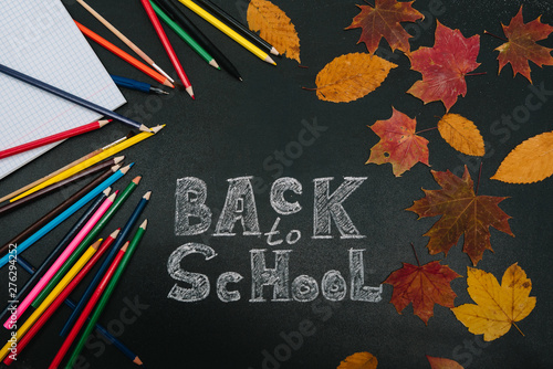 Back to school concept. School and office supplies on blackboard background.