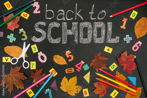 Back to school concept. School and office supplies on blackboard background.