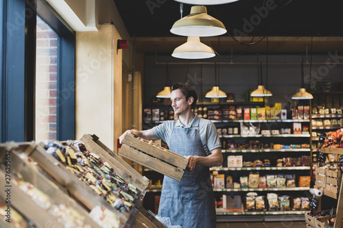 Small business owner of a food market stocking shelves