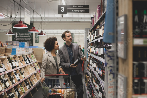 Couple choosing wine in grocery store