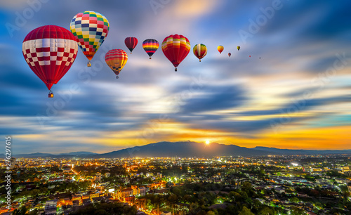Colorful hot-air balloons flying over Chiang Mai City twilight with mountain at Dot Inthanon background in Chiang Mai, Thailand. © somchairakin