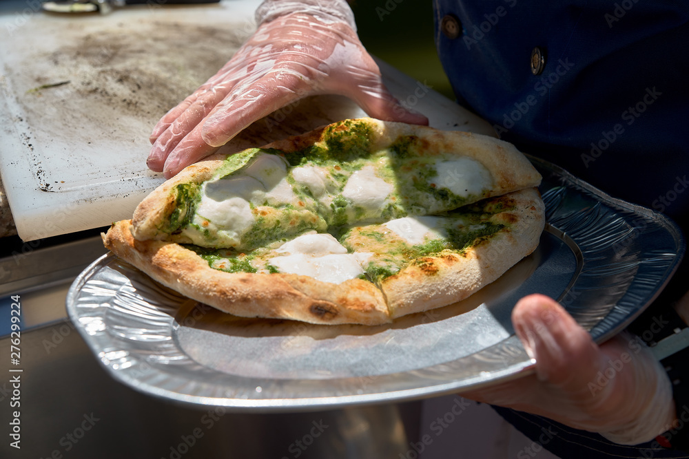 Chef prepares focaccia bread pizza baked in the oven at the market