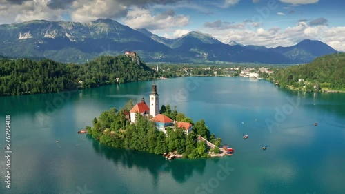 Lake Bled, Slovenia - 4K aerial footage of flying around Pilgrimage Church of the Assumption of Maria above Lake Bled (Blejsko Jezero) on a beautiful summer day with blue sky and clouds photo