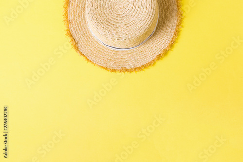 yellow retro straw hat top view with copy space. summer concept on yellow background