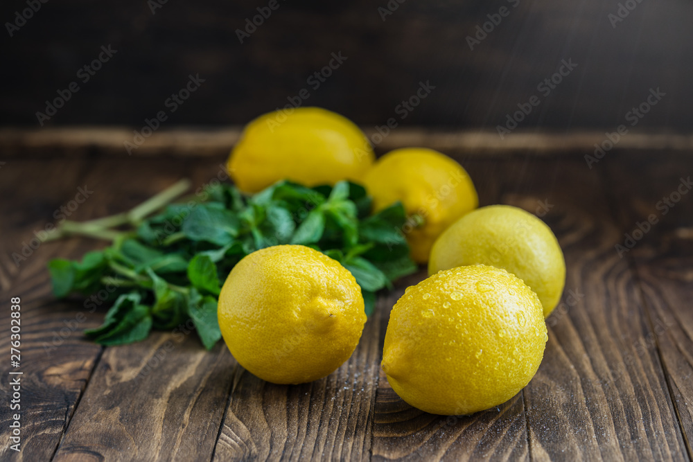 Lemons and mint leaves on wooden background