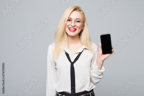 Business woman smiling showing a blank smart phone screen isolated on white background
