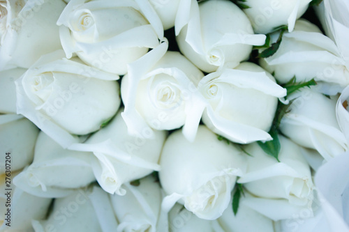wedding rings on a bouquet of white roses