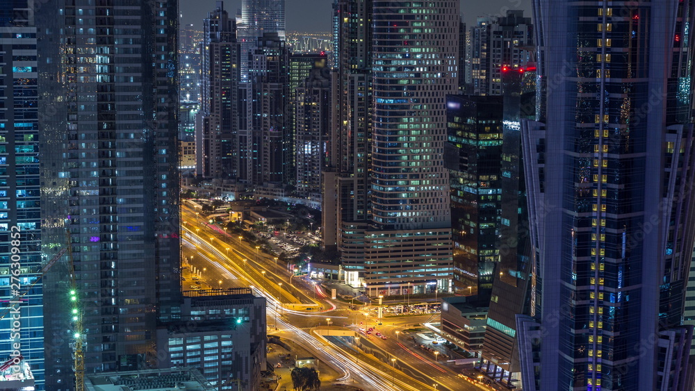 Aerial view of towers in Business Bay with traffic on the road night timelapse.