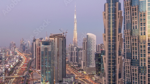 Evening skyline with modern skyscrapers and traffic on sheikh zayed road day to night timelapse in Dubai, UAE.