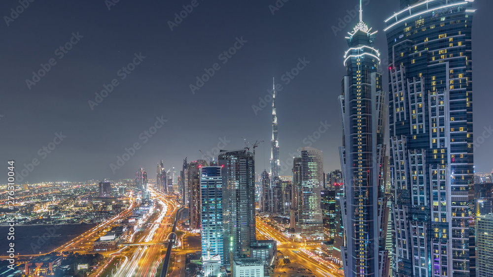Evening skyline with modern skyscrapers and traffic on sheikh zayed road night timelapse in Dubai, UAE.