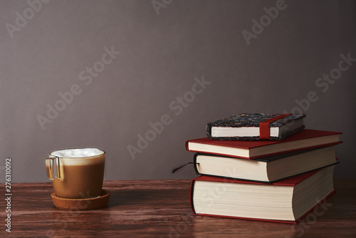  Coffee and books on a brown wooden table.