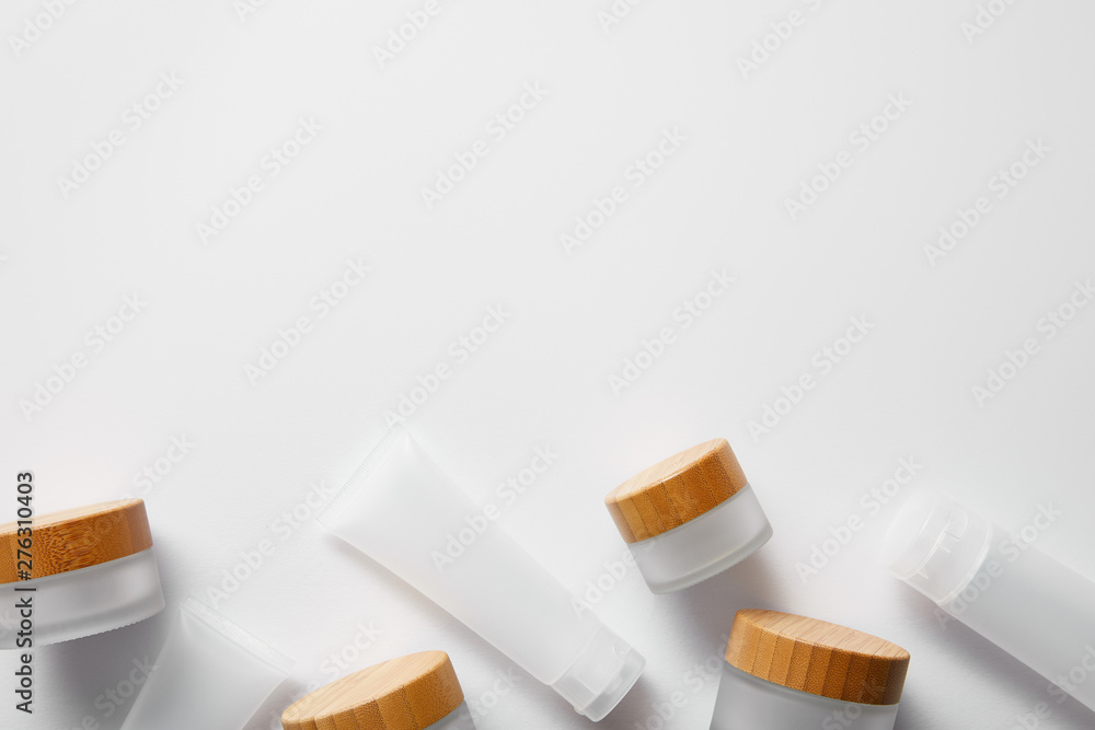 top view of few empty jars and cream tubes on white top view of few empty jars and cream tubes on white
