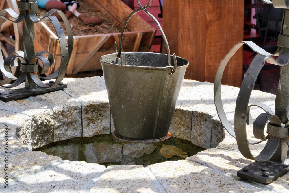 Old well and metal bucket. Details of Castle of Tirana (Kalaja e Tiranes), new public space with traditional and modern shops, restaurants, bars. Tirana, Albania Old well and metal bucket. Details of Castle of Tirana (Kalaja e Tiranes), new public space with traditional and modern shops, restaurants, bars. Tirana, Albania