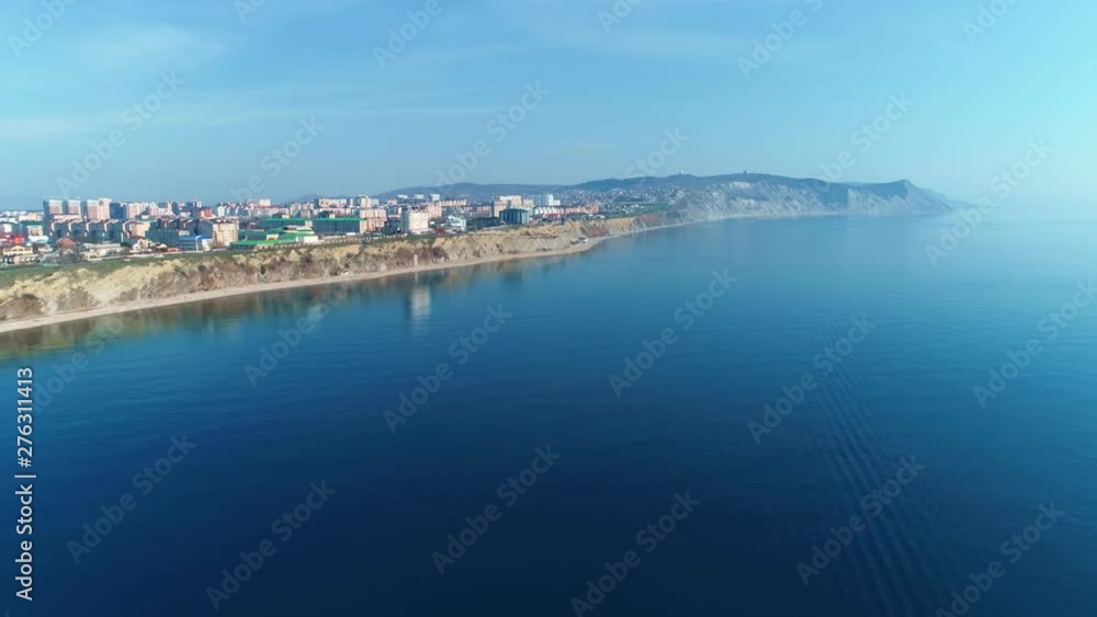 Seascape background with coastal town in mountains with buildings and sea view, aerial footage. Travel concept. Seascape background with coastal town in mountains with buildings and sea view, aerial footage. Travel concept.