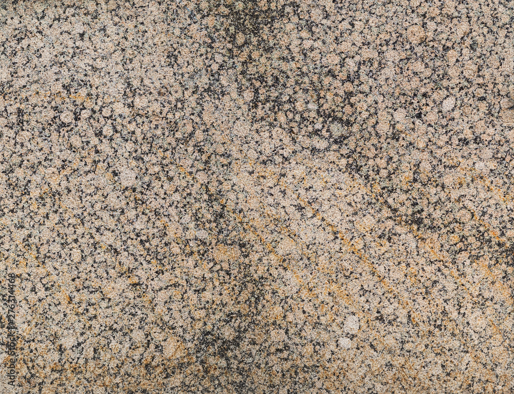 Close-up of a spotted light red or orange and black granite stone wall. High resolution full frame textured background. Close-up of a spotted light red or orange and black granite stone wall. High resolution full frame textured background.