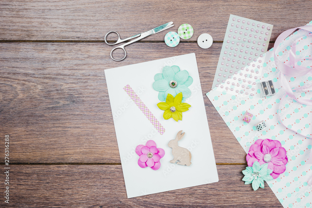 Making greeting card with flower; buttons; ribbon and beads on wooden table