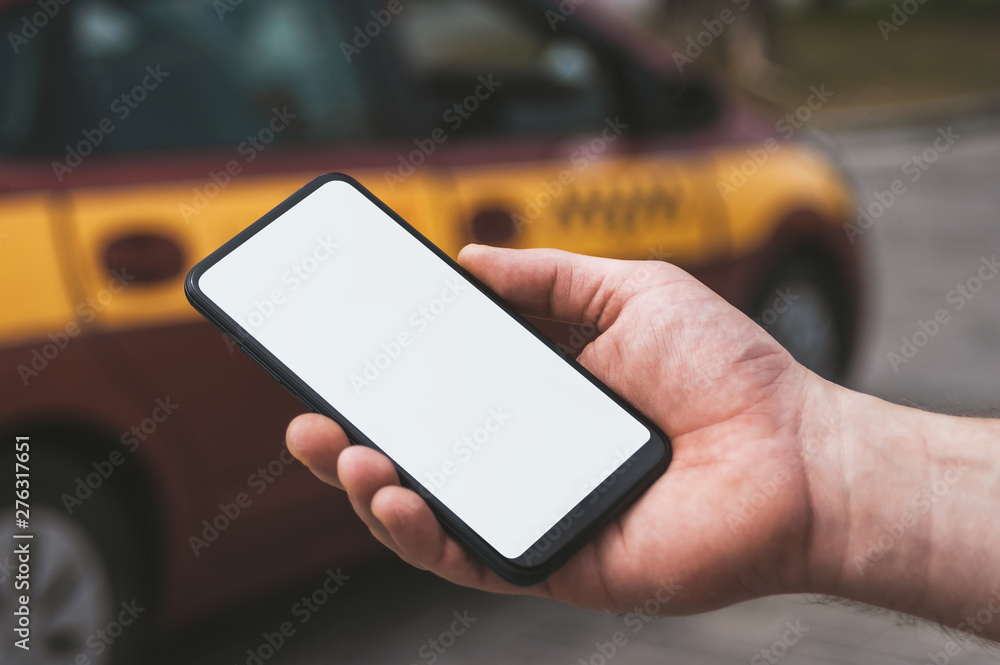 Mock up of a smartphone in hand, on the background of a taxi car.