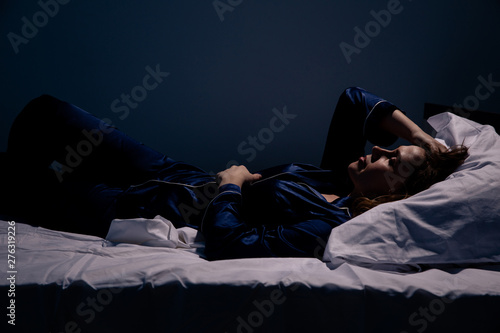 Sad alone woman lying the bed. Insomnia concept photo