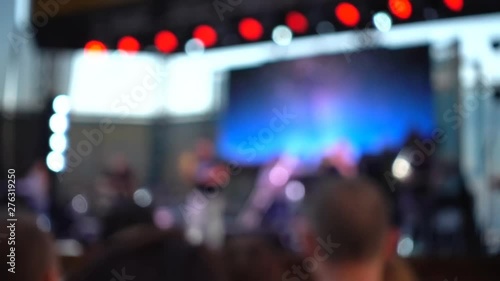 Concert on the stage. Crowd of people and musicians on the scene. Out of focus.