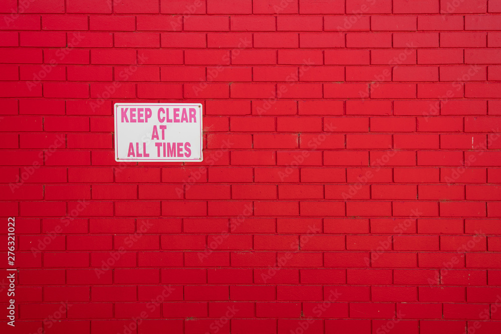Fototapeta premium painted red brick wall and sign