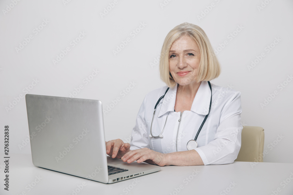 Female doctor in cabinet in lab uniform working on a computer Female doctor in cabinet in lab uniform working on a computer