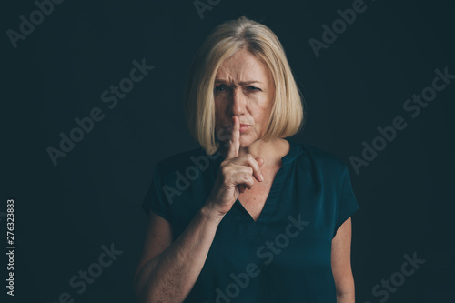 Woman showing to keep silence isolated photo