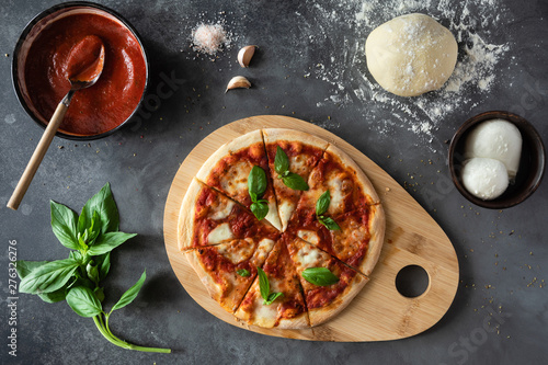 Top view of Pizza Margherita on black stone background. Classic Italian Pizza Margarita with Tomato sause, Basil and Mozzarella Cheese background. photo