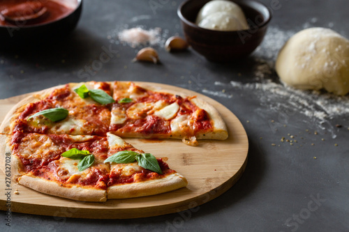 Pizza Margherita on black stone background. Classic Italian Pizza Margarita with Tomato sause, Basil and Mozzarella Cheese background.