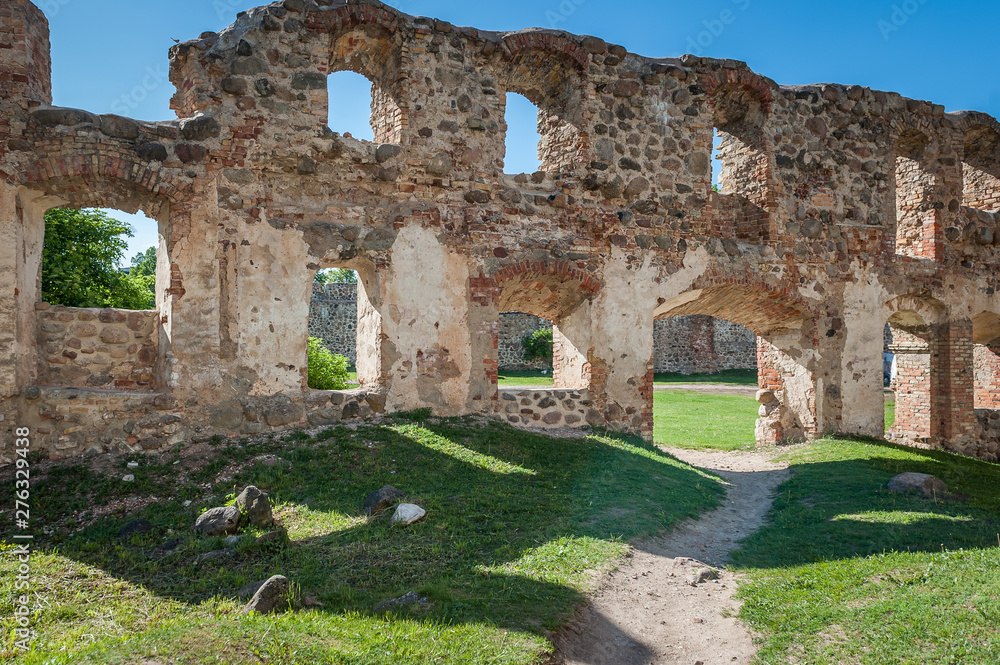 Ancient ruins of a knight's castle in Dobele. Overall view of the courtyard and surrounding area across  window openings in the wall. Dobele, Latvia.
