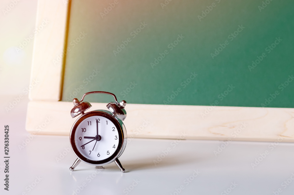 Back to school. Alarm clock on the background of the school board. School background with space for your text. Back to school. Alarm clock on the background of the school board. School background with space for your text.