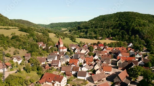 Low aerial view over the rooftops in the town of Geislinger, Germany with the Martinskirche Evangelic church and dramatic landscape behind. photo