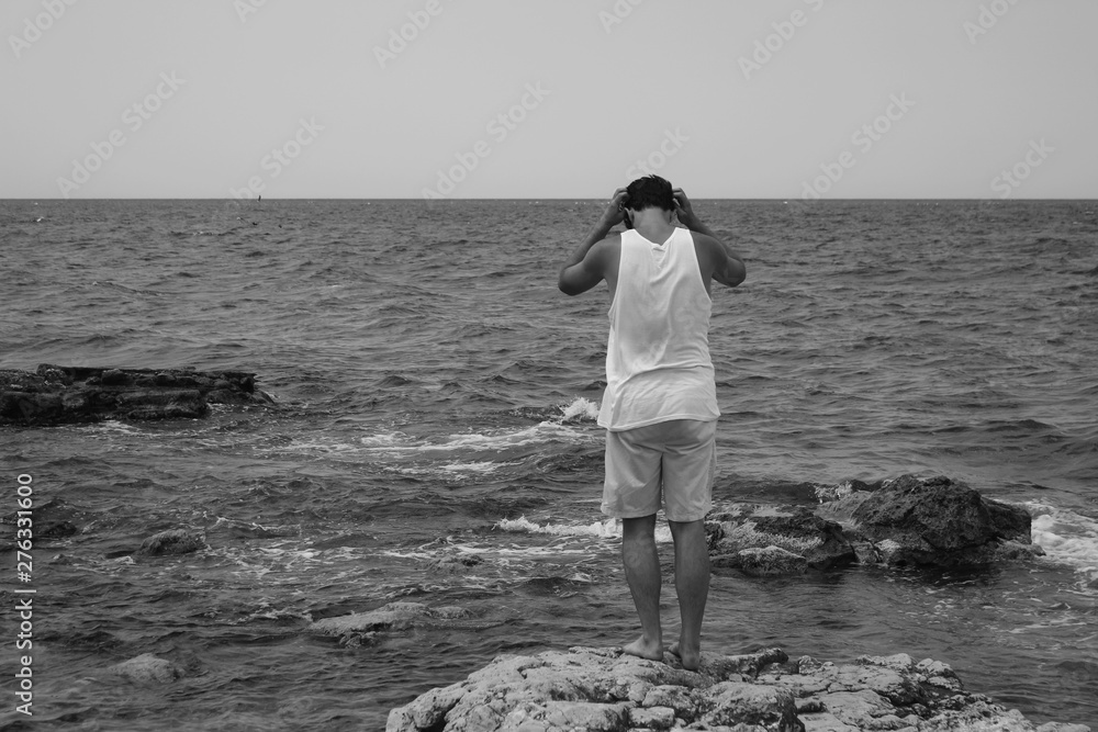 Meditative and thoughtful men on a sea coast. Black sea in Crimea. Black and white