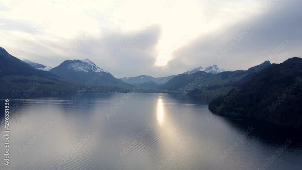 Aerial drone static shot of a lake covered with mist and fog surrounded by snow covered mountains and villages in Mont Blanc, France Aerial drone static shot of a lake covered with mist and fog surrounded by snow covered mountains and villages in Mont Blanc, France