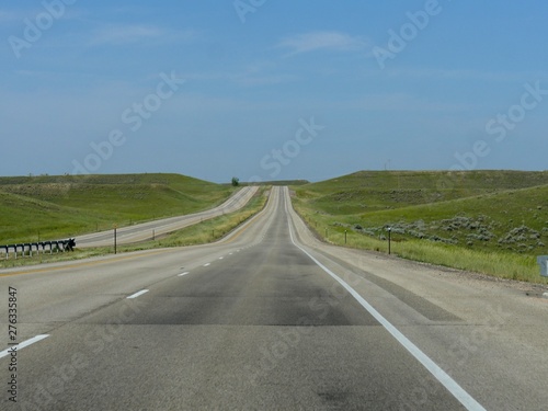 Paved road with a roadside sign with distance to Buffalo and Sheridan just out of Gillette, Wyoming. © raksyBH