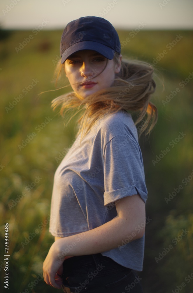 beautiful young blonde with long flowing hair on a blurred background of summer greenery beautiful young blonde with long flowing hair on a blurred background of summer greenery