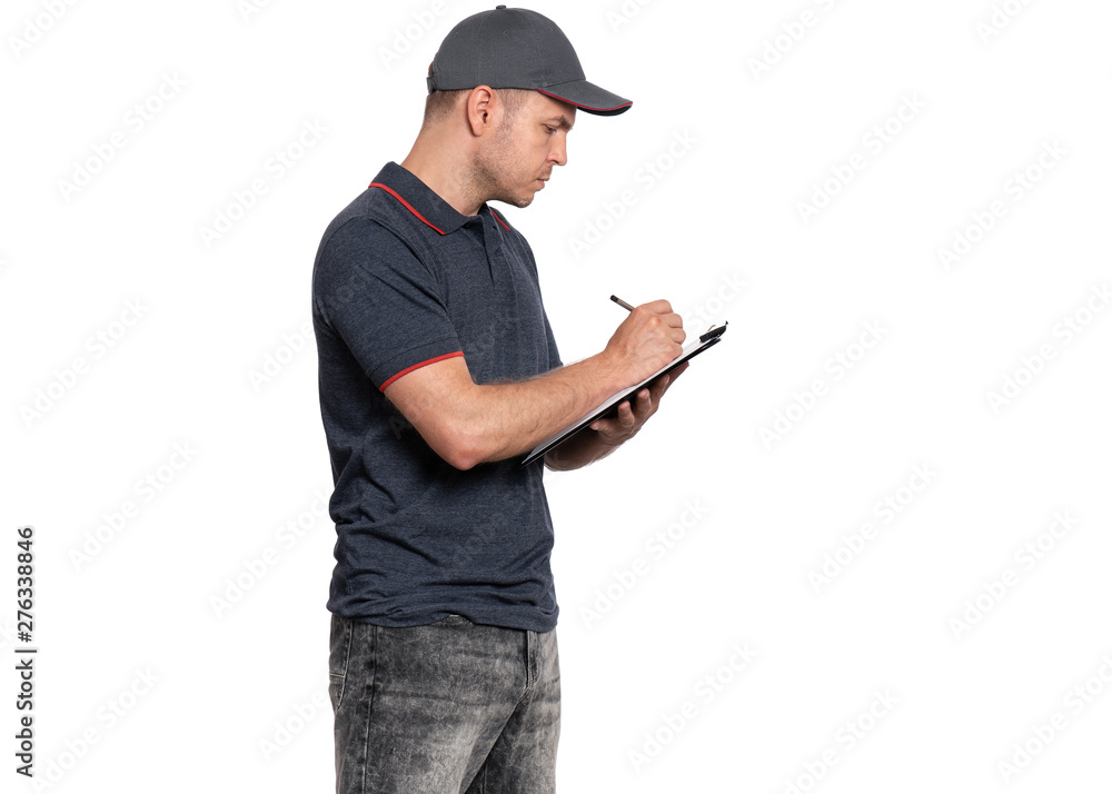 Portrait of Delivery man in cap holding clipboard with papers document and pen, writes. Handsome man Courier isolated on white background. Portrait of Delivery man in cap holding clipboard with papers document and pen, writes. Handsome man Courier isolated on white background.