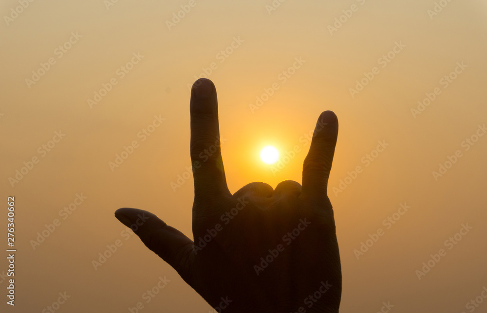 Silhouette hand finger symbol with twilight sunset sky. Hand sign 