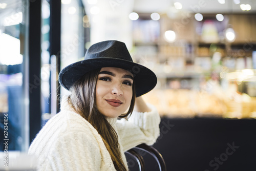 Beautiful smiling young woman wearing black hat on head