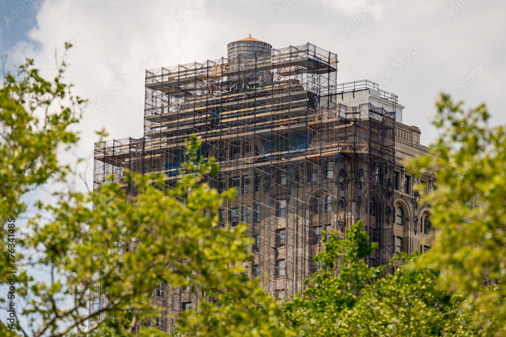 Building under construction with scaffolding in New York Manhattan - obrazy, fototapety, plakaty 