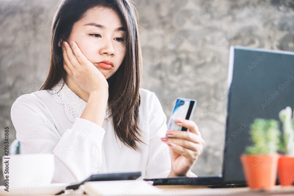 sad Asian woman having problem with limit credit card for online shopping, over spending concept sad Asian woman having problem with limit credit card for online shopping, over spending concept