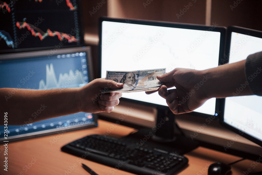 Here's your payment. Day of salary in the modern office with screens and graphs on them Here's your payment. Day of salary in the modern office with screens and graphs on them