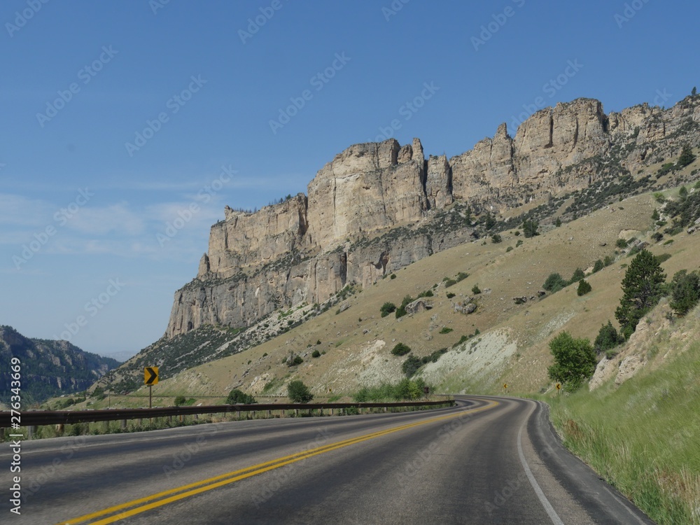 Wide view of scenic granite cliffs and rock formations along a winding road at Bighorn Mountains in Wyoming.1 Wide view of scenic granite cliffs and rock formations along a winding road at Bighorn Mountains in Wyoming.1