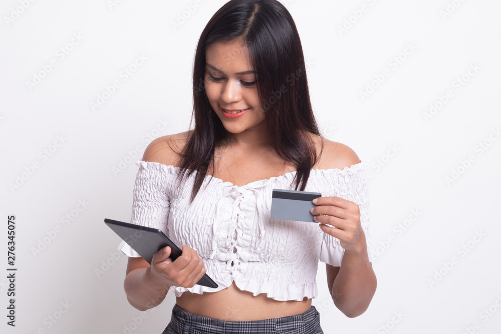 Young Asian woman is shopping online with credit card and tablet. Young Asian woman is shopping online with credit card and tablet.
