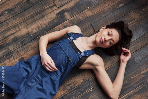 Top view. Girl in the blue uniform for the work is lying on wooden floor having relax © standret