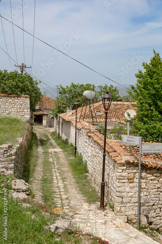 Kleine Strasse mit Steinmauer und Strassenlaterne