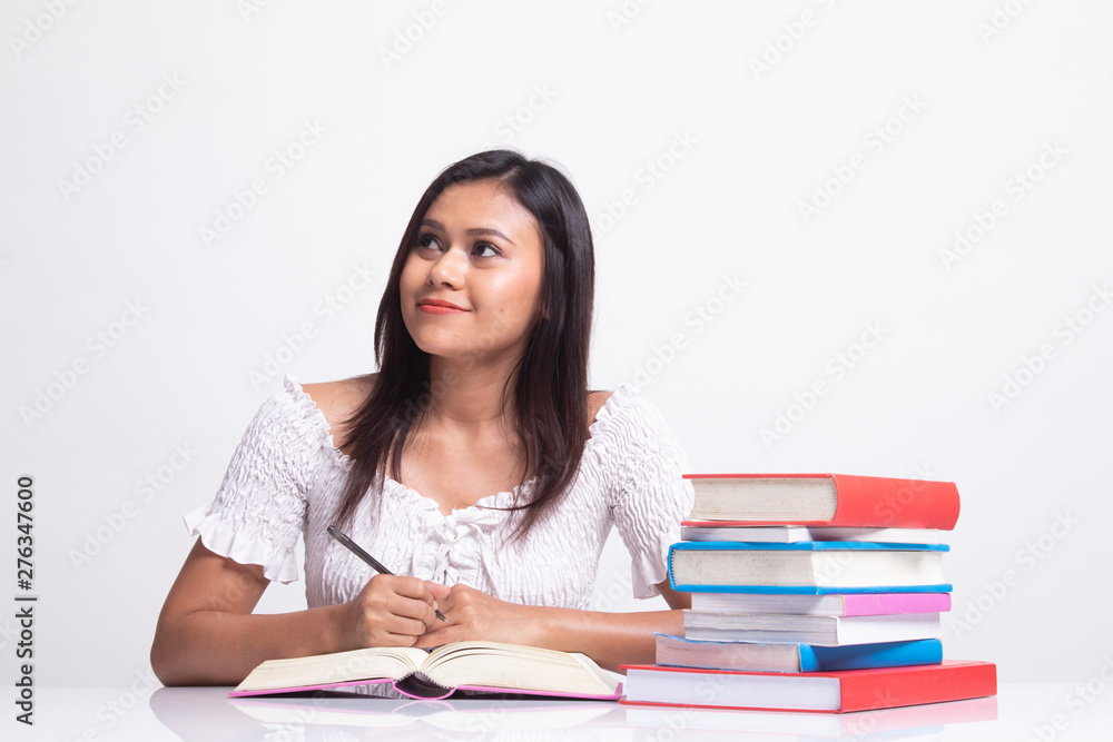 Young Asian woman read a book with books on table. Young Asian woman read a book with books on table.