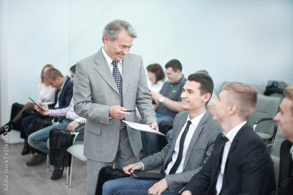 Manager holds a working meeting with the company's employees. Manager holds a working meeting with the company's employees.