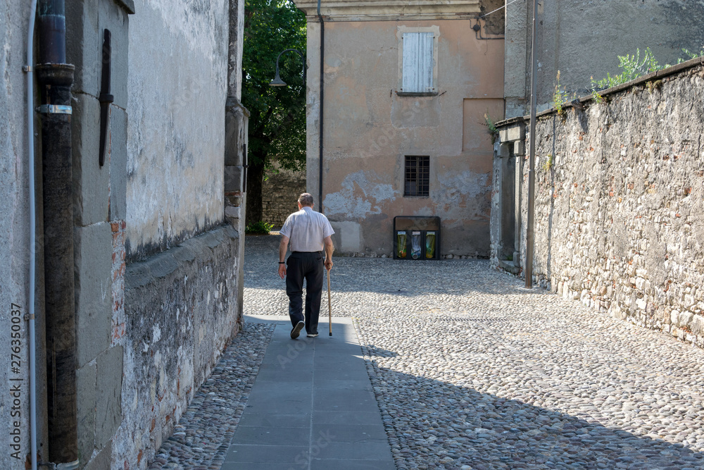 Old man walking alone in the street