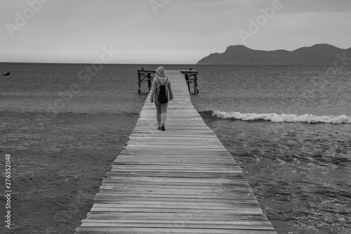 Person walking on jetty at Mallorca Coast - black and white